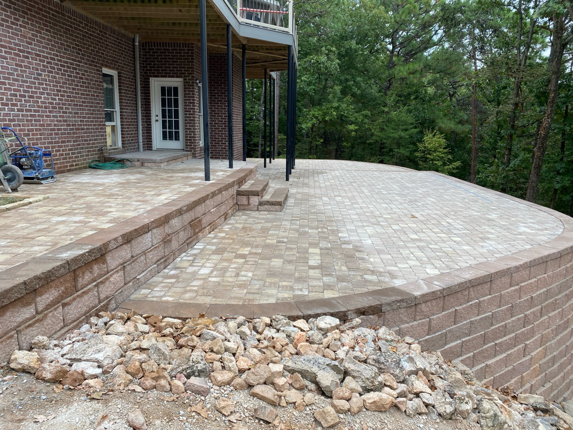 Retaining wall and paver patio installed beneath a home deck